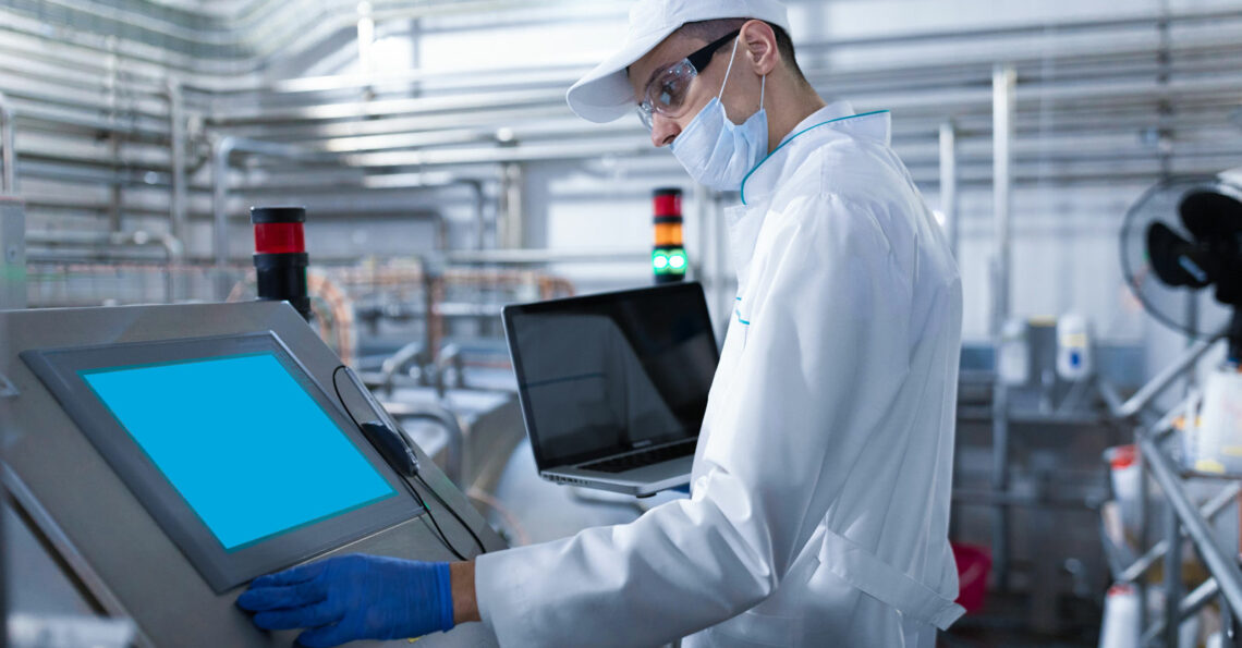 Man in a cleanroom viewing information on a screen